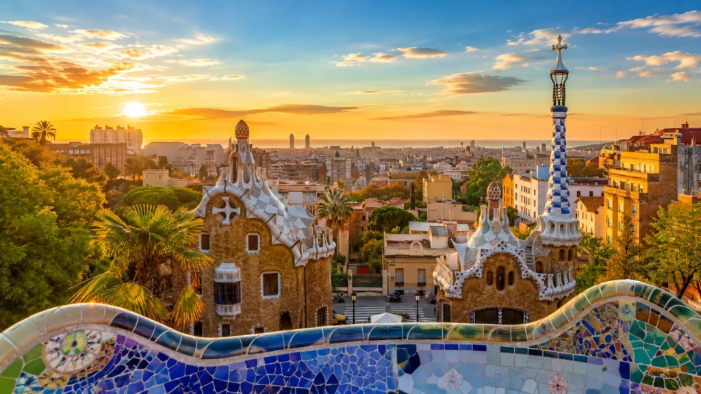 Park Güell in Barcelona overlooking the city and Mediterranean coast at sunset.