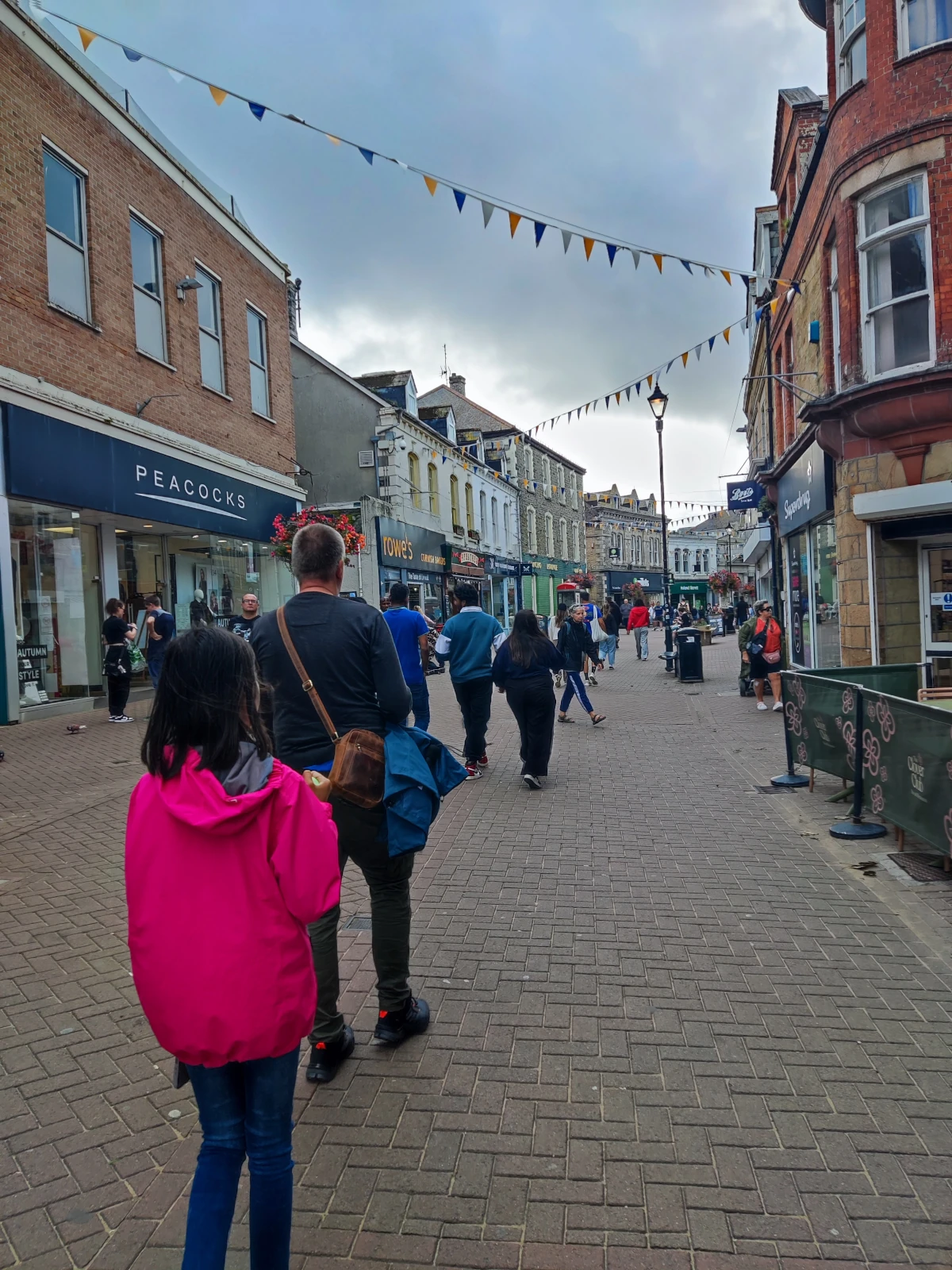 Pedestrian shopping street in Newquay town centre, Cornwall, with shops and passersby