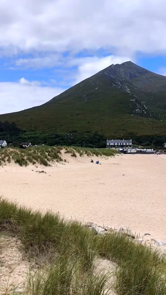 Dugort Beach on Achill Island, Co. Mayo, with sand dunes in front and the peak of Slievemore rising behind the village